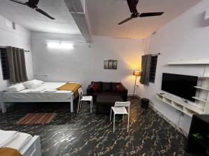 阿加尔塔拉Raj Andar Guest House的一间带床、沙发和电视的卧室