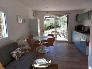 a kitchen and a living room with a table and chairs at Maisonnette au cœur de la nature in Néoules
