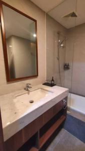 a bathroom with a sink and a mirror and a shower at Full Furnished 1Bedroom Apartment Kawana Golf Residence Jababeka in Pegadungan