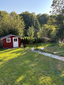 a small red shed in a yard with a driveway at Ferienhaus chez nous in Merzig