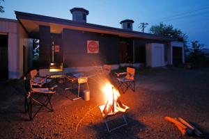 a group of chairs around a fire in front of a building at Starry Sky Cottage 15 in Kitami