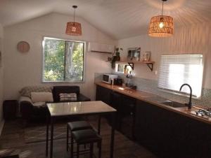 a kitchen and living room with a table and a couch at Hull River Guesthouse Mission Beach in Mission Beach