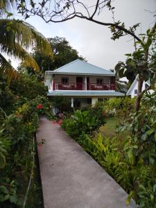 a house with a pathway in front of it at Lucy's guesthouse in La Digue