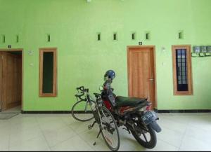 a motorcycle parked in a room with a bike at Ganesa Women Homestay in Kediri