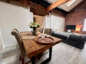 a dining room with a wooden table and a couch at Ranmoor Serviced Apartments at Victoria Quays in Sheffield
