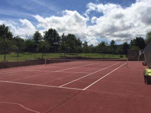 a tennis court with a net on top of it at La Soulterie in Crouttes