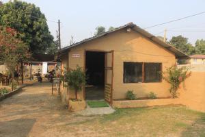a small yellow house with a door open at Chilax House and Retreat Center in Sauraha +83 photos