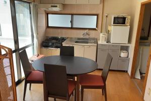 a small kitchen with a table and chairs in a kitchen at Yonamine House in Okinawa City