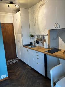a kitchen with white cabinets and a sink at Petit Studio hyper centre vue lac thonon-o-phil-de-l-eau in Thonon-les-Bains +12 photos
