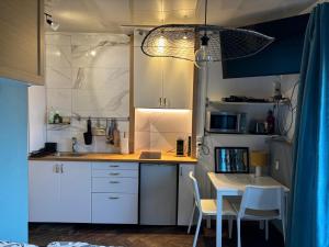 a kitchen with white cabinets and a table with chairs at Petit Studio hyper centre vue lac thonon-o-phil-de-l-eau in Thonon-les-Bains
