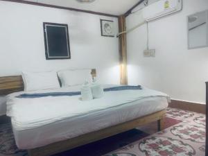 a bedroom with a bed with two white pillows at Amelie House in Luang Prabang