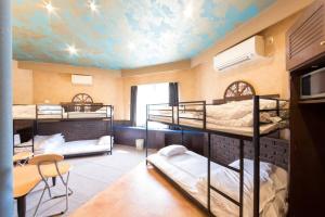 a room with three bunk beds and a ceiling with a mural at Starry Sky Cottage 17 in Bihoro