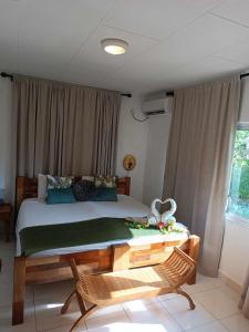 a bedroom with a bed and a table with flowers on it at Lucy's guesthouse in La Digue