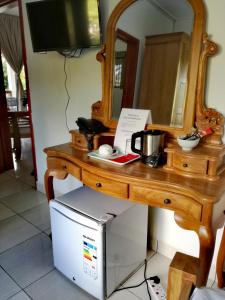 a desk with a mirror and a computer under it at Lucy's guesthouse in La Digue