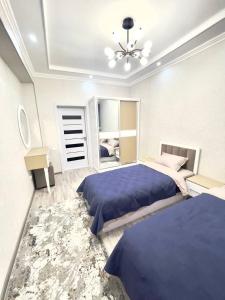 a bedroom with two beds and a ceiling fan at Harmony Homestay in Samarkand
