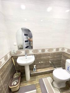 a bathroom with a sink and a toilet and a mirror at Harmony Homestay in Samarkand +5 photos