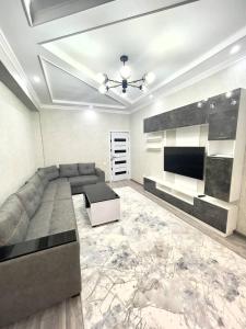 a living room with a couch and a flat screen tv at Harmony Homestay in Samarkand
