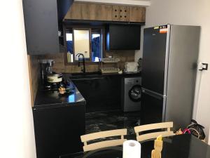 a kitchen with black counters and a refrigerator at Djerba Haus in Al Maqārisah