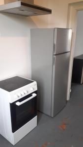 a kitchen with a stove and a refrigerator at Petit AmienSud idéal pour 2 in Saint-Sauflieu