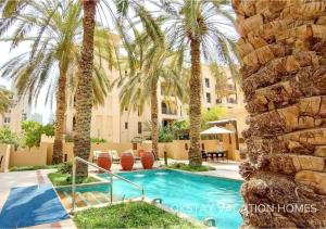 una piscina en un complejo turístico con palmeras en 5 Min Walk to Burj Khalifa 2BHK Luxury Downtown Burj Haven, en Dubái