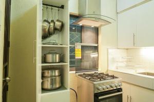 a kitchen with a stove and some pots and pans at Tagaytay Overlooking Taal. Free Parking Fast Wi-Fi in Tagaytay