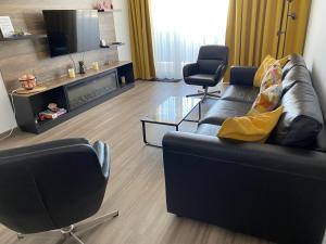 un soggiorno con un divano e una televisione di BrasoVista - PAJ Premium Apartments in URBAN Plaza a Braşov