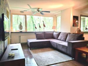 a living room with a couch and a window at 't Klokhuis Natuur"lijk" genieten in Schoonoord