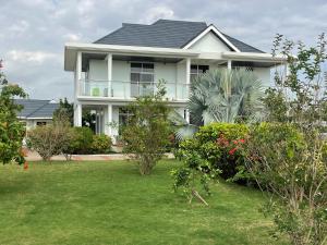 a white house with a yard with plants at Dar Villa in Dar es Salaam