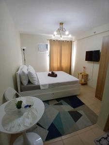 a small room with a bed and a table at Mountain View Studio at Marina Spatial - 300Mbps, Pool, City Centre in Dumaguete