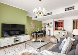 Una sala de estar con un sofá y un televisor. en 5 Min Walk to Burj Khalifa 2BHK Luxury Downtown Burj Haven, en Dubái