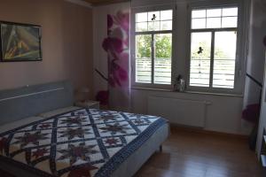 a bedroom with a bed and two windows at FeWo Schmetterling in Limbach - Oberfrohna