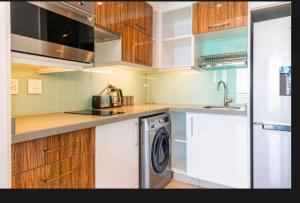 a kitchen with a washer and a dishwasher in it at Umhlanga Lagoon Drive Top Sea Facing Unit in Durban