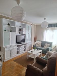 a living room with a couch and a tv at Apartamento Cueto in Soto del Barco