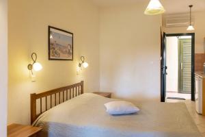 a bedroom with a bed with a pillow on it at Elenas Beach Studios in Vourvourou