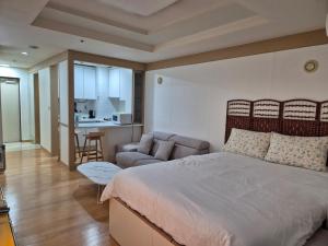 um quarto com uma cama, um sofá e uma cozinha em 1 min to Seolleung Urban Space em Seul