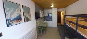 a small room with a table and a kitchen at studio au pied des pistes in Bolquere Pyrenees 2000