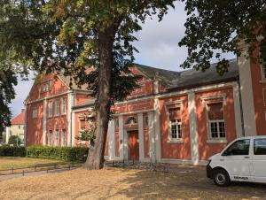 a white car parked in front of a large house at Fewo Grete - Minde in Tangermünde
