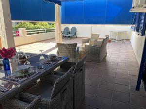 un patio con mesa, sillas y una pared azul en Beachfront 3 Bed Apt San Luis De Sabinillas, en San Luis de Sabinillas