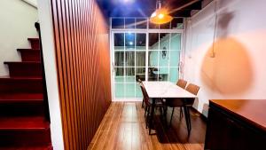 Un comedor con una mesa y una ventana. en uouRangnamHouse, en Bangkok