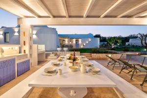 a white table on the patio of a house at Tenuta PANORAMICAPULIA - Luxury Masseria Ostuni in Ostuni +38 photos