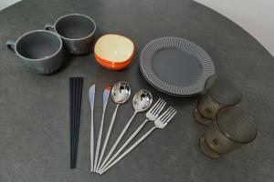 a table with forks and plates and utensils at Le Cocon Nakarokugo by Tranova in Tokyo