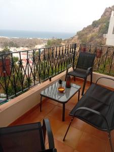 a balcony with chairs and a table and a view at Apartamento El Cortijo in Mojácar