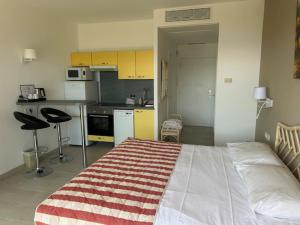 a bedroom with a large bed and a kitchen at Hôtel La Flore in Villefranche-sur-Mer