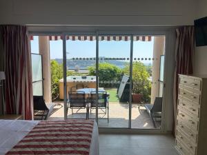 a bedroom with a view of a patio with a table and chairs at Hôtel La Flore in Villefranche-sur-Mer