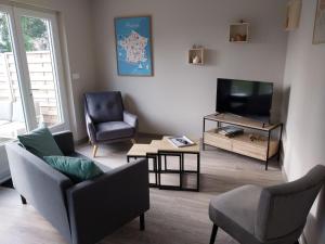 a living room with two chairs and a television at Le gîte Maimbevillois in Maimbeville