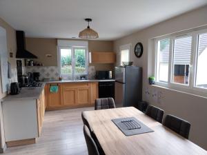 a kitchen with a wooden table and a dining room at Le gîte Maimbevillois in Maimbeville