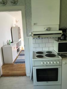 a kitchen with a stove and a white oven at Sommar och vinter i Rottneros in Sunne