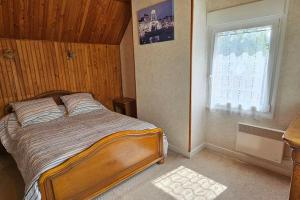 a bedroom with a bed and a window at La Maison Bricquebetaise in Bricquebec