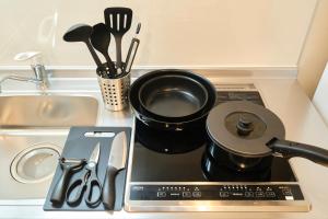 a stove top with a pot on it next to a sink at Le Cocon Nakarokugo by Tranova in Tokyo