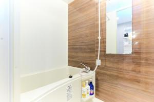a bathroom with a sink and a mirror on the wall at Le Cocon Nakarokugo by Tranova in Tokyo